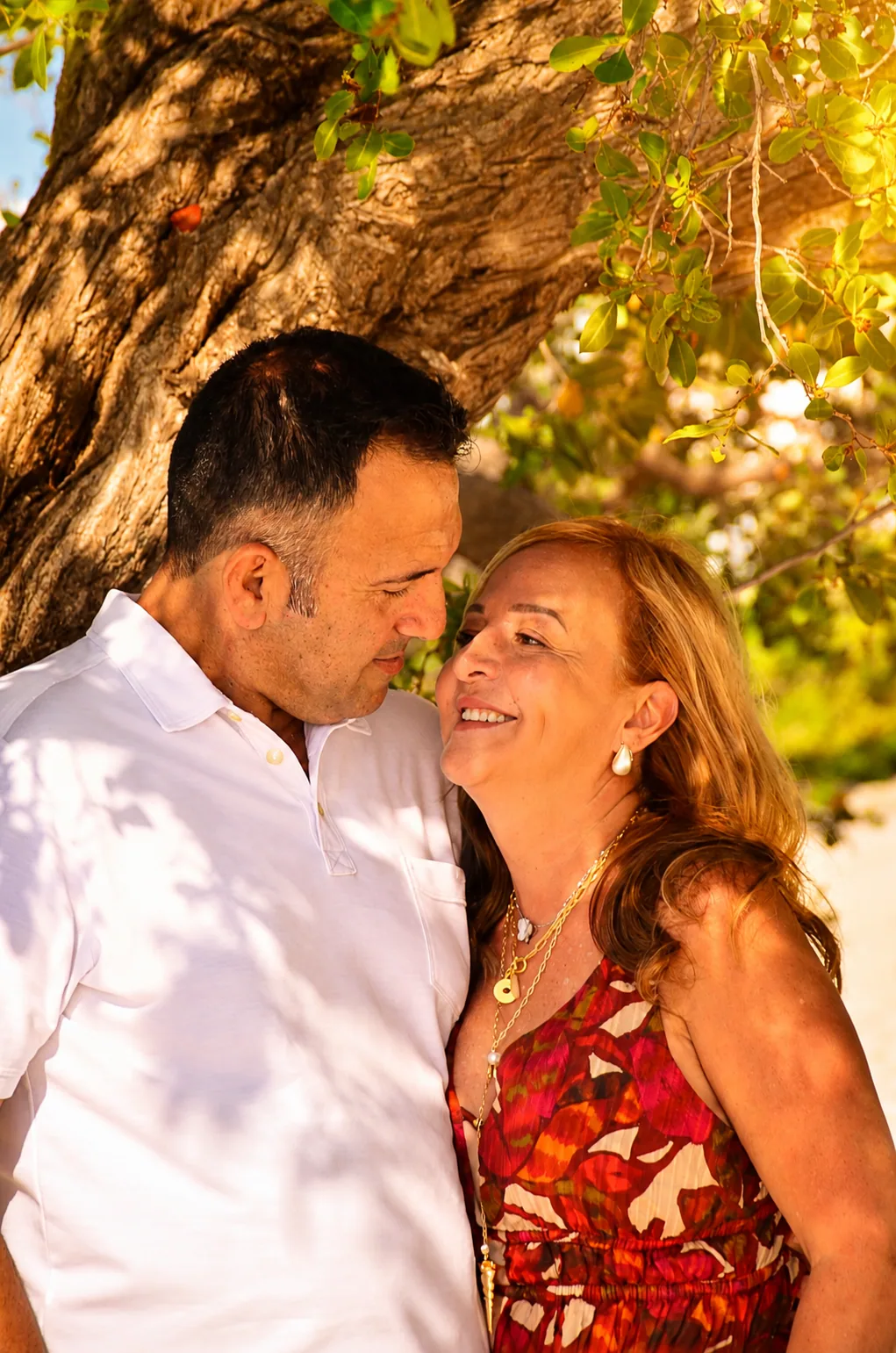 Pareja sonriendo durante una sesi&oacute;n al atardecer